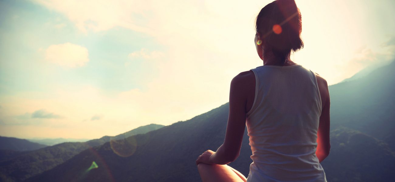 49934174 - young yoga woman at sunrise mountain peak