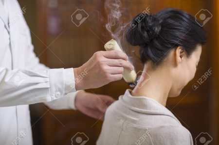 Senior Chinese doctor giving moxibustion